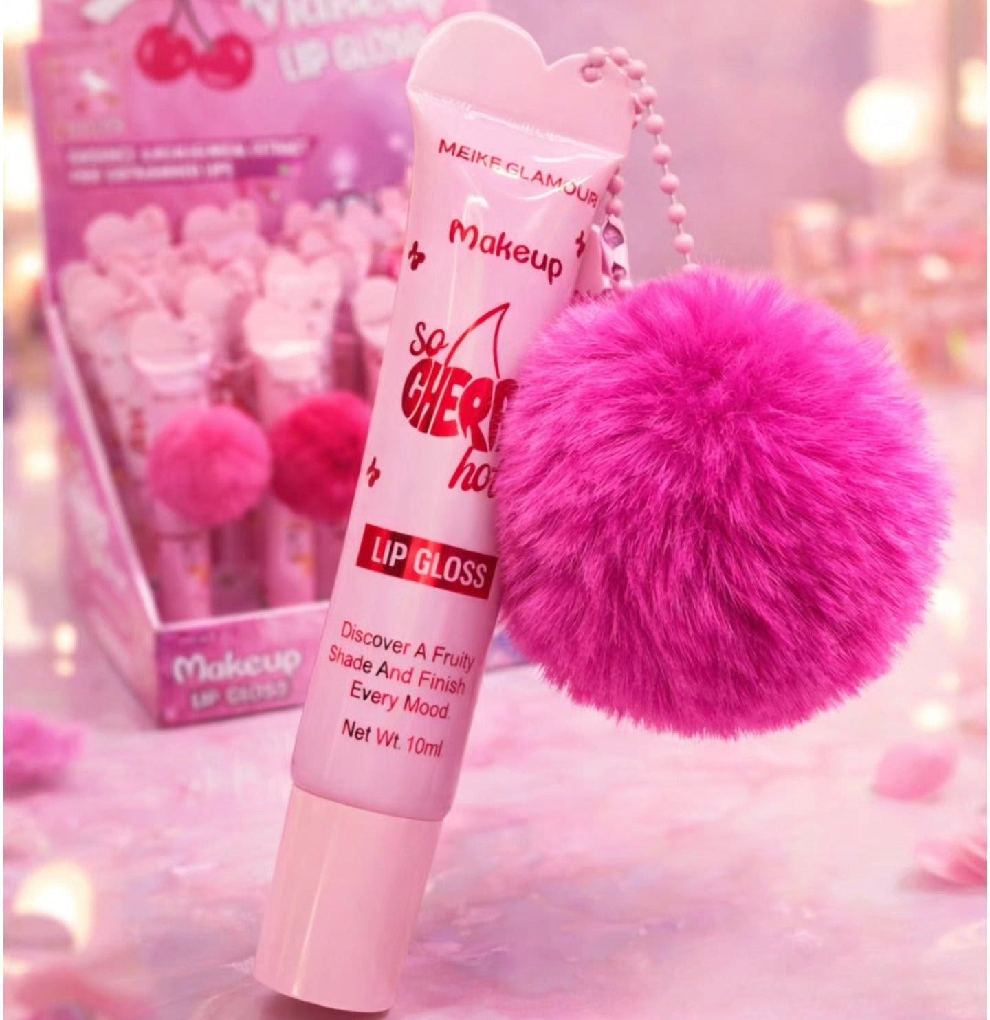 Pink lip gloss with a fluffy pink keychain on a soft pink background